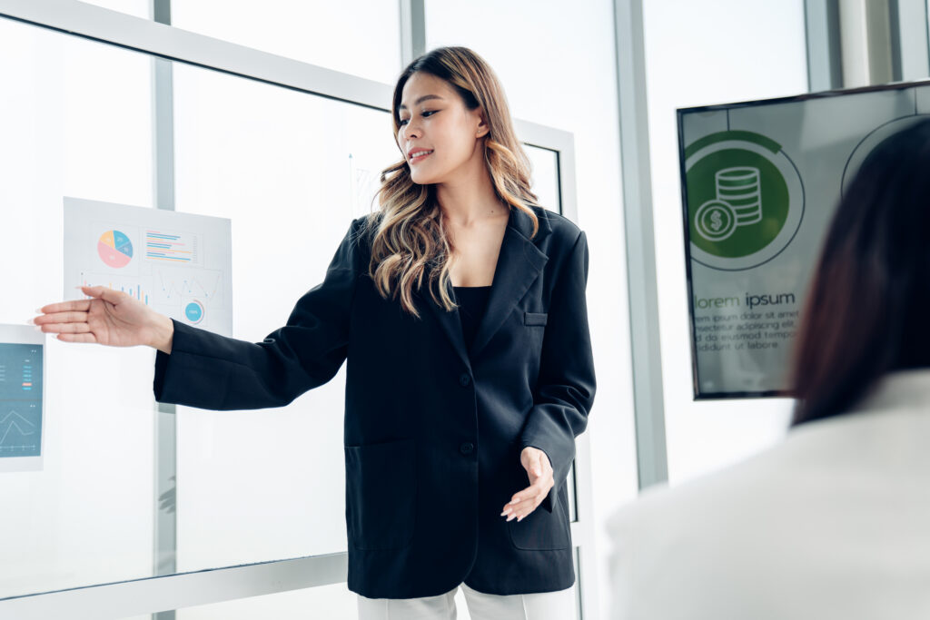 A young business professional delivering a presentation in a bright, modern office space.